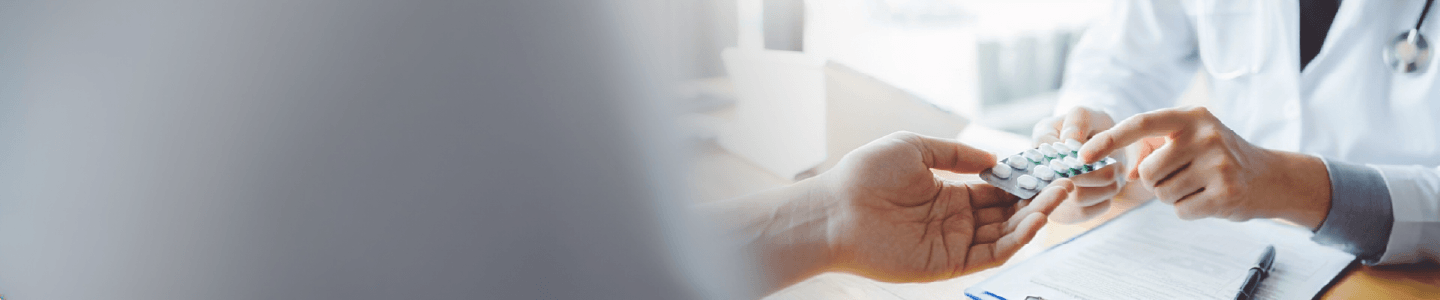 Lege som gir medisiner til pasient, illustrerer behandling av forstoppelse med legemidler
