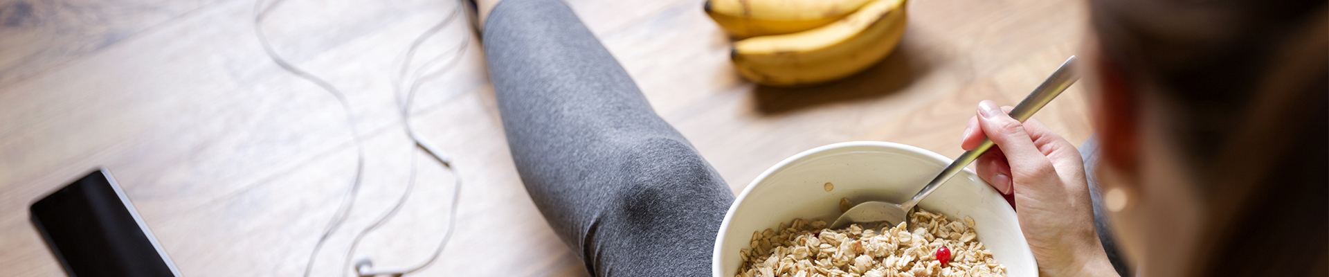 Person som spiser fiberrik frokost med havregryn og banan, viser kosthold som hjelper mot treg mage
